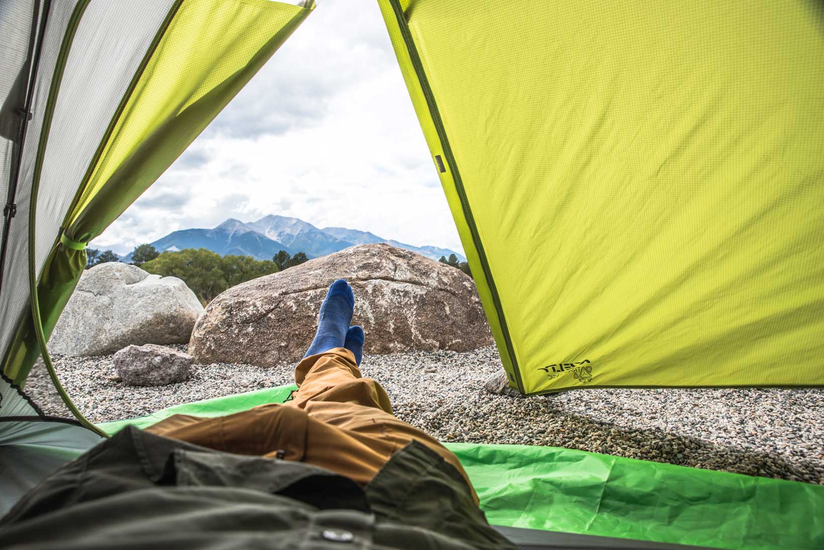 The view a person sees from the inside of their tent of a snowtopped mountain peak