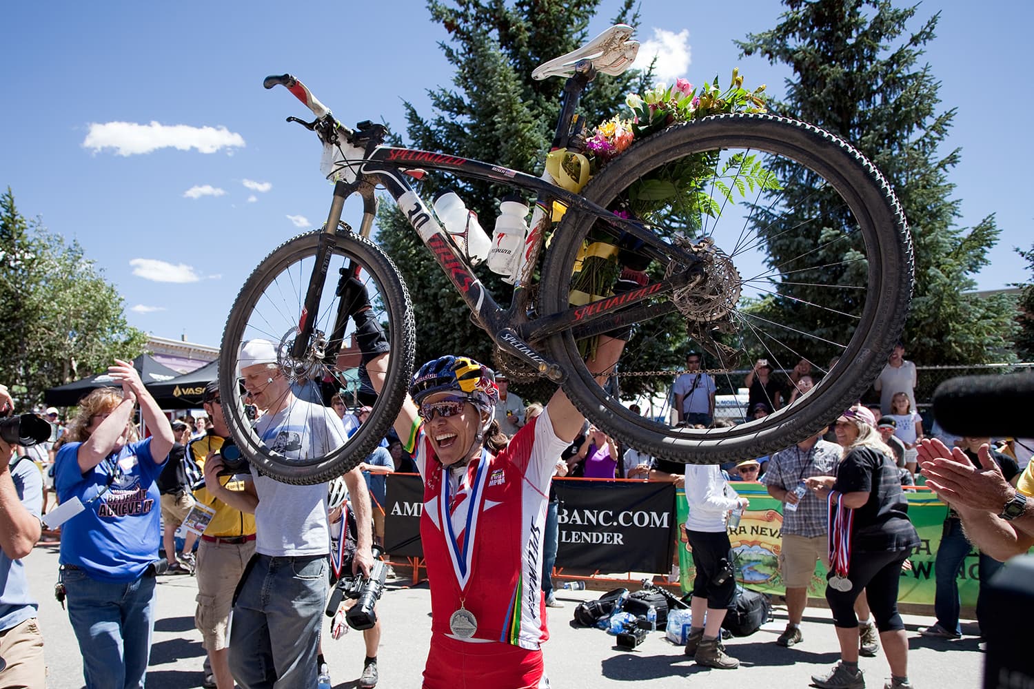 A champion holds their bike in the air at the Leadville Trail 100 Bike Series