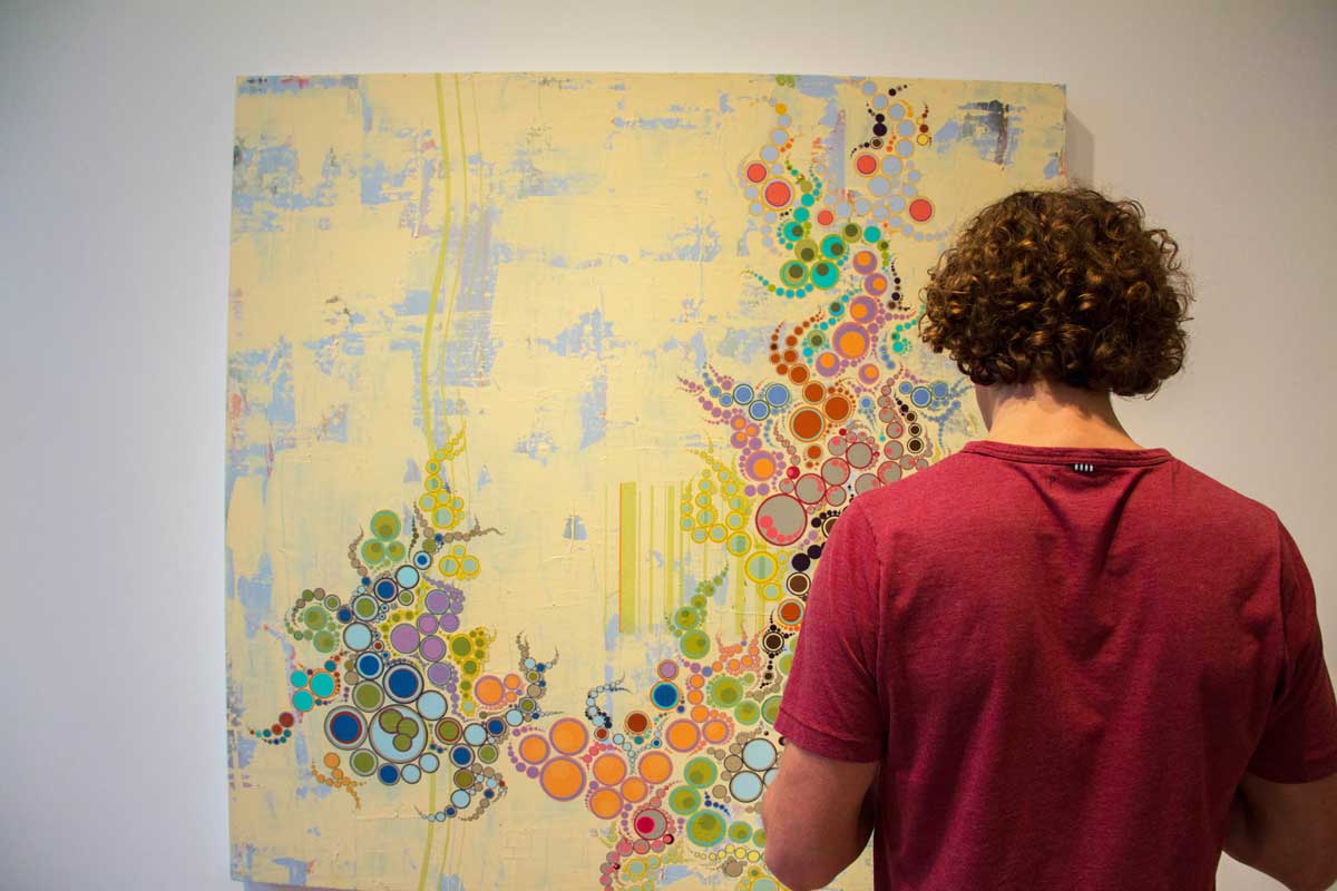 Man looks at painting at First Friday at Denver's Art District on Santa Fe