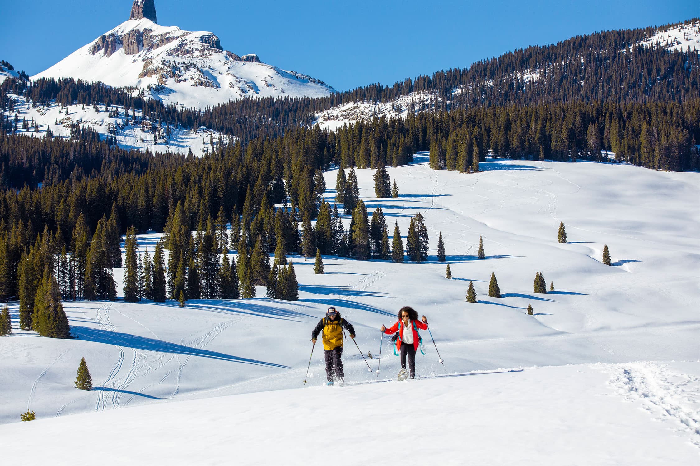 Two skiers enjoy Colorado's backcountry with mountains in background