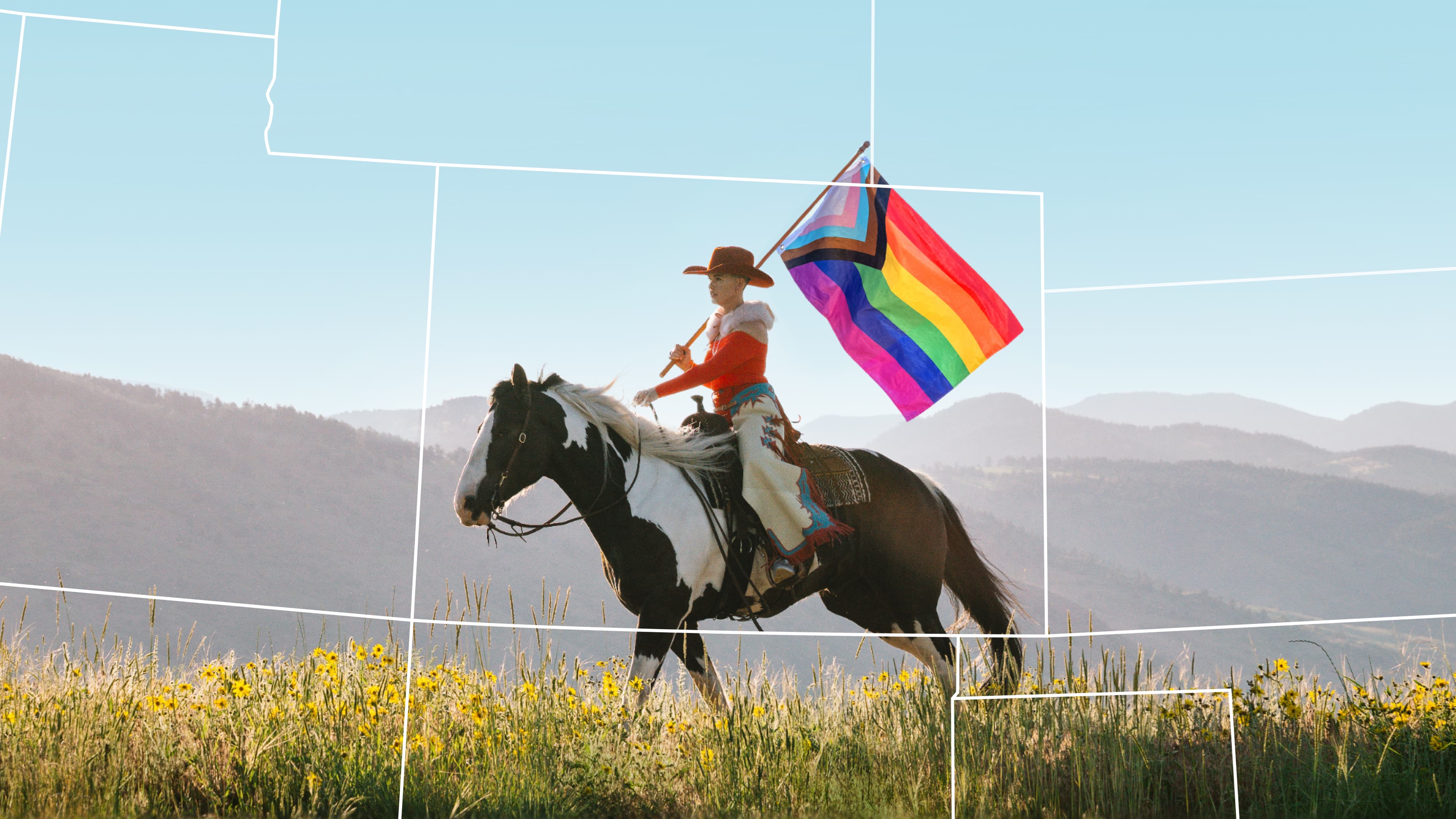 A person on a horse holds a progress pride flag