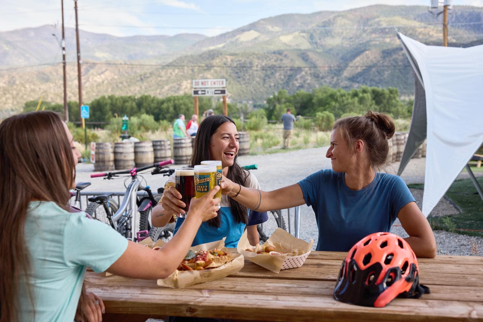 Three woman cheers beer glasses at a Colorado brewery in Poncha Springs