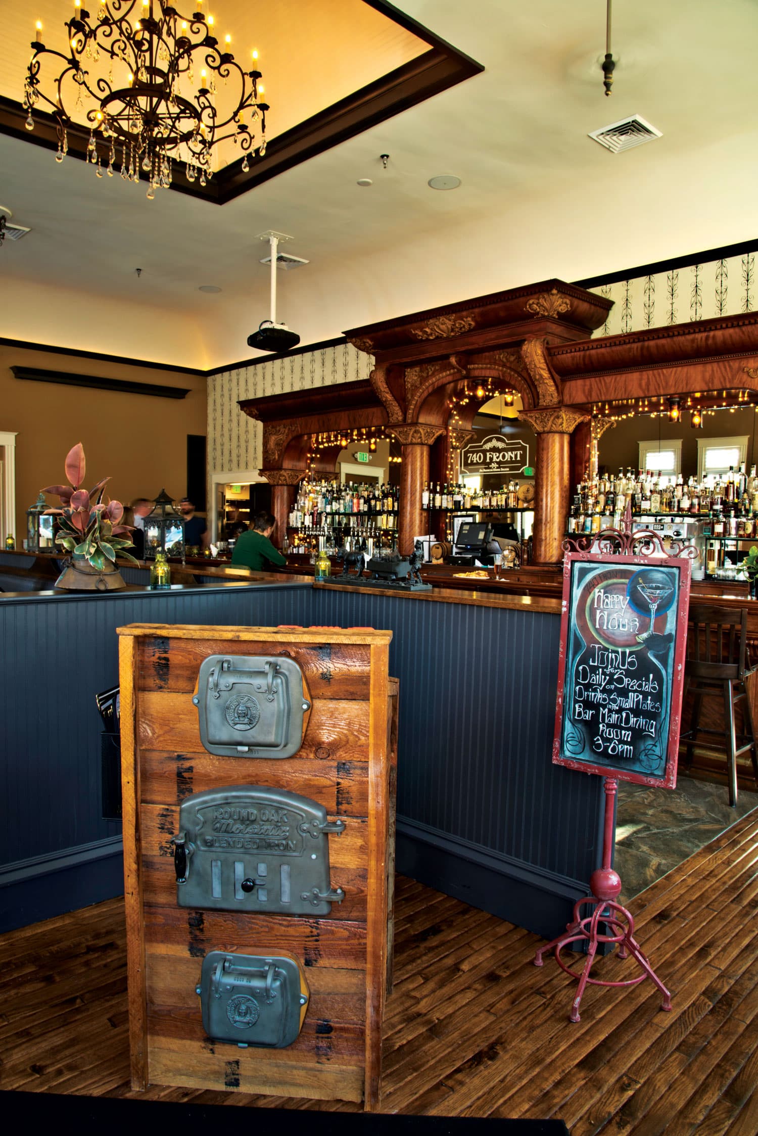 A bar with intricately carved molding and a mirrored back serves thirsty patrons in Louisville, Colorado.