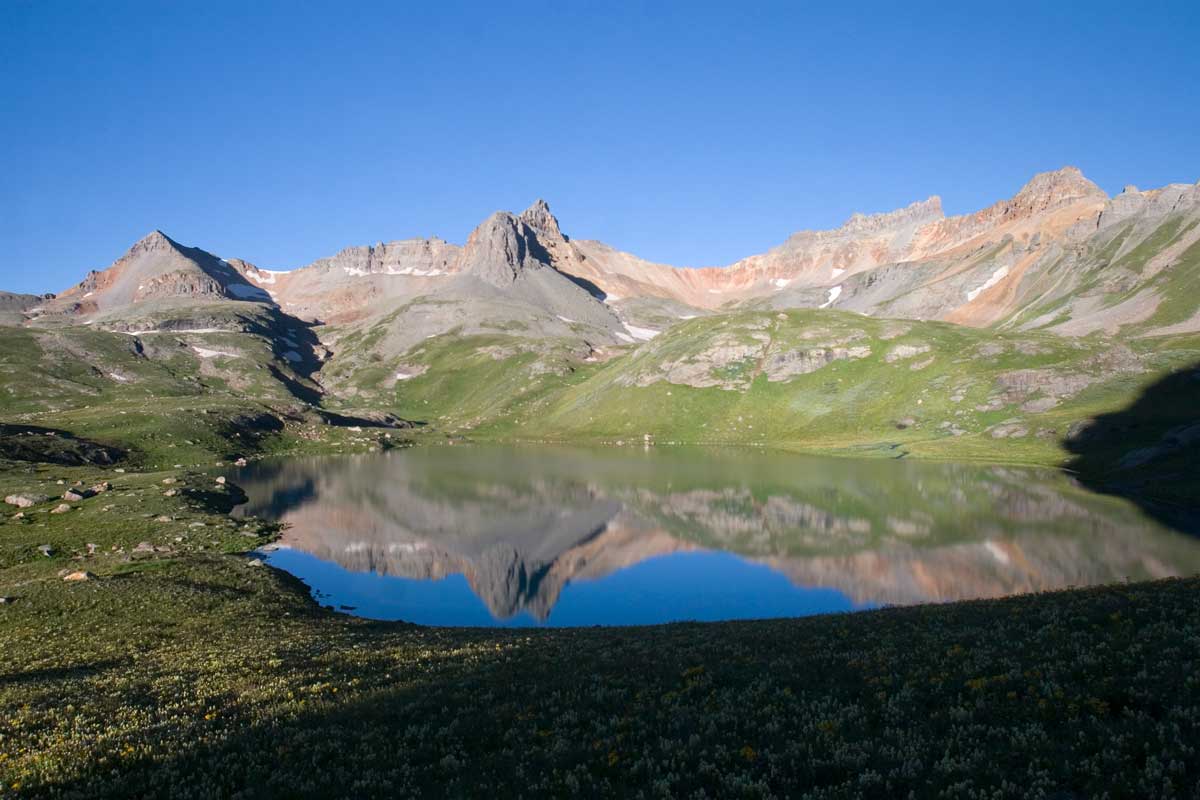An alpine lake surrounded by peaks in Ice Lakes Basin