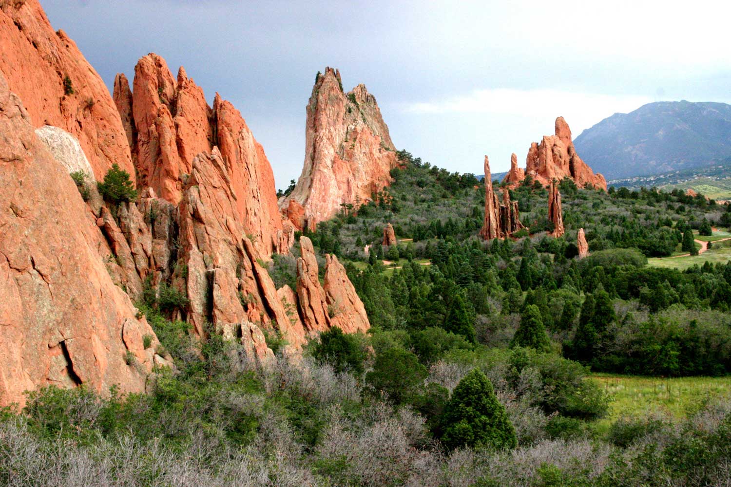 Red-rock towers and spires form a broken wall of rock amid the evergreen trees and shrubs in the Garden of the Gods near Colorado Springs, Colorado.