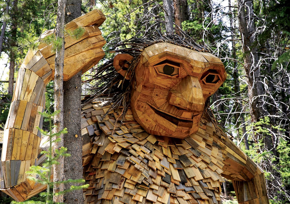 Breckenridge's friendly troll, Isak Heartstone, he is a massive wooden creature, smiling and holding a tree trunk