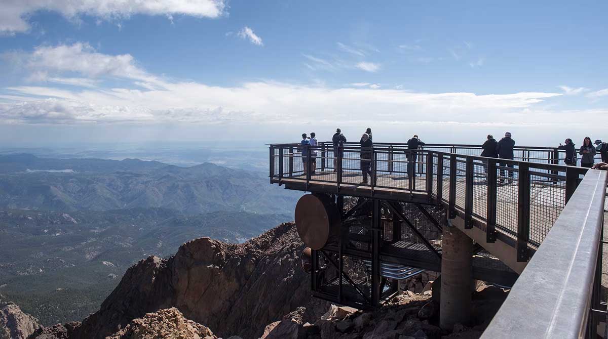 A metal and wood platform extends over the side of a cliff