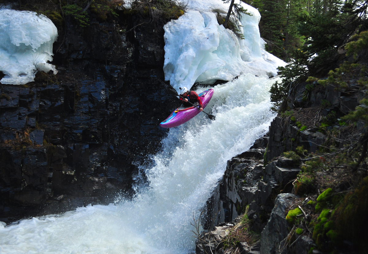 A kayaker rides down the falls of a steep creek gushing with water during spring runoff in Gunnison and Crested Butte, Colorado