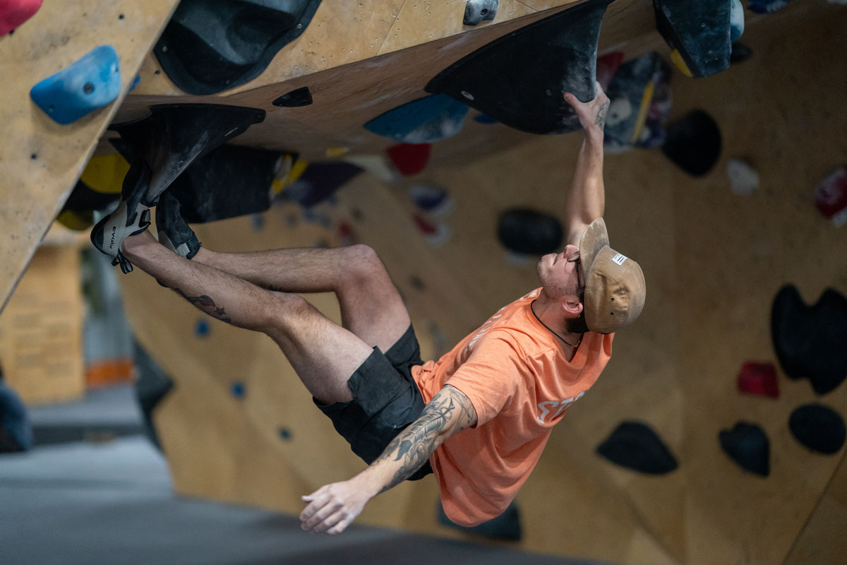 Man climbing and holding on tightly at Climbing Collective indoor gym in Greeley.