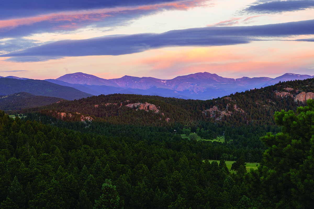 Golden hour casting over mountains and trees above Alderfer/Three Sisters.