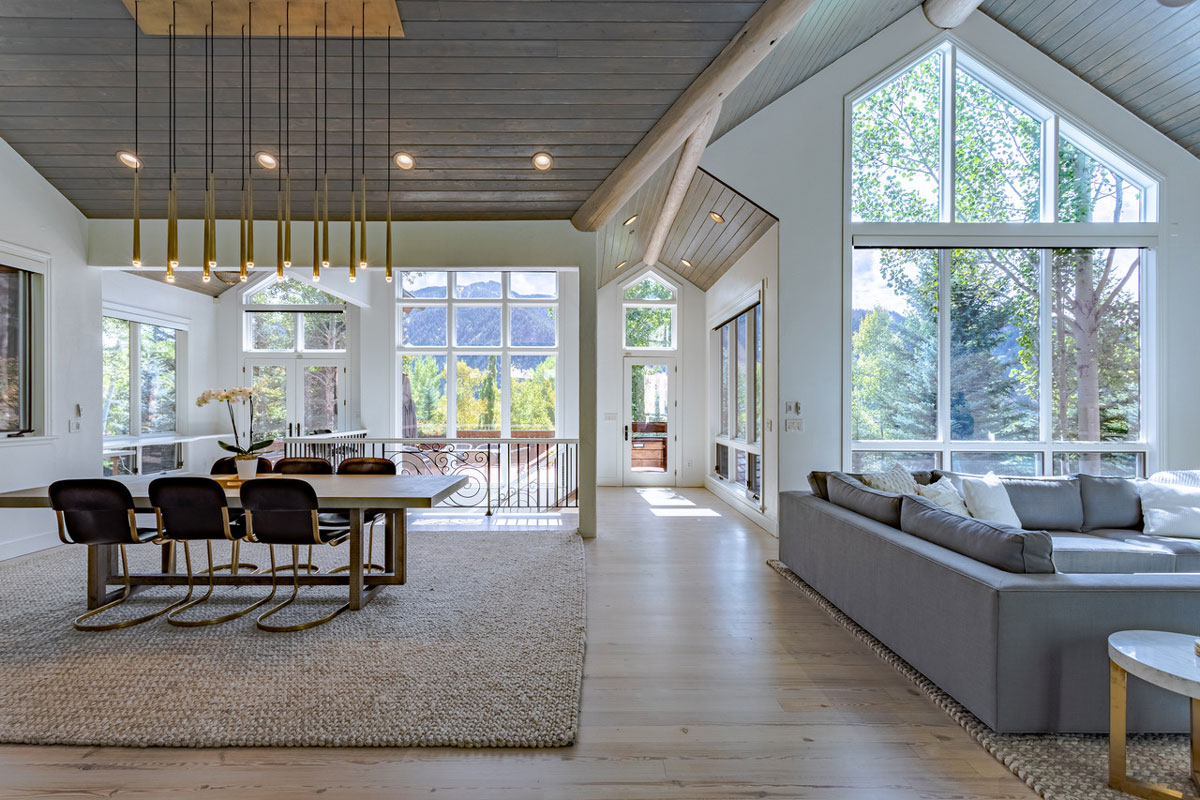 An airy and brightly lit dining area with large windows revealing mountain views in Aspen, Colorado.
