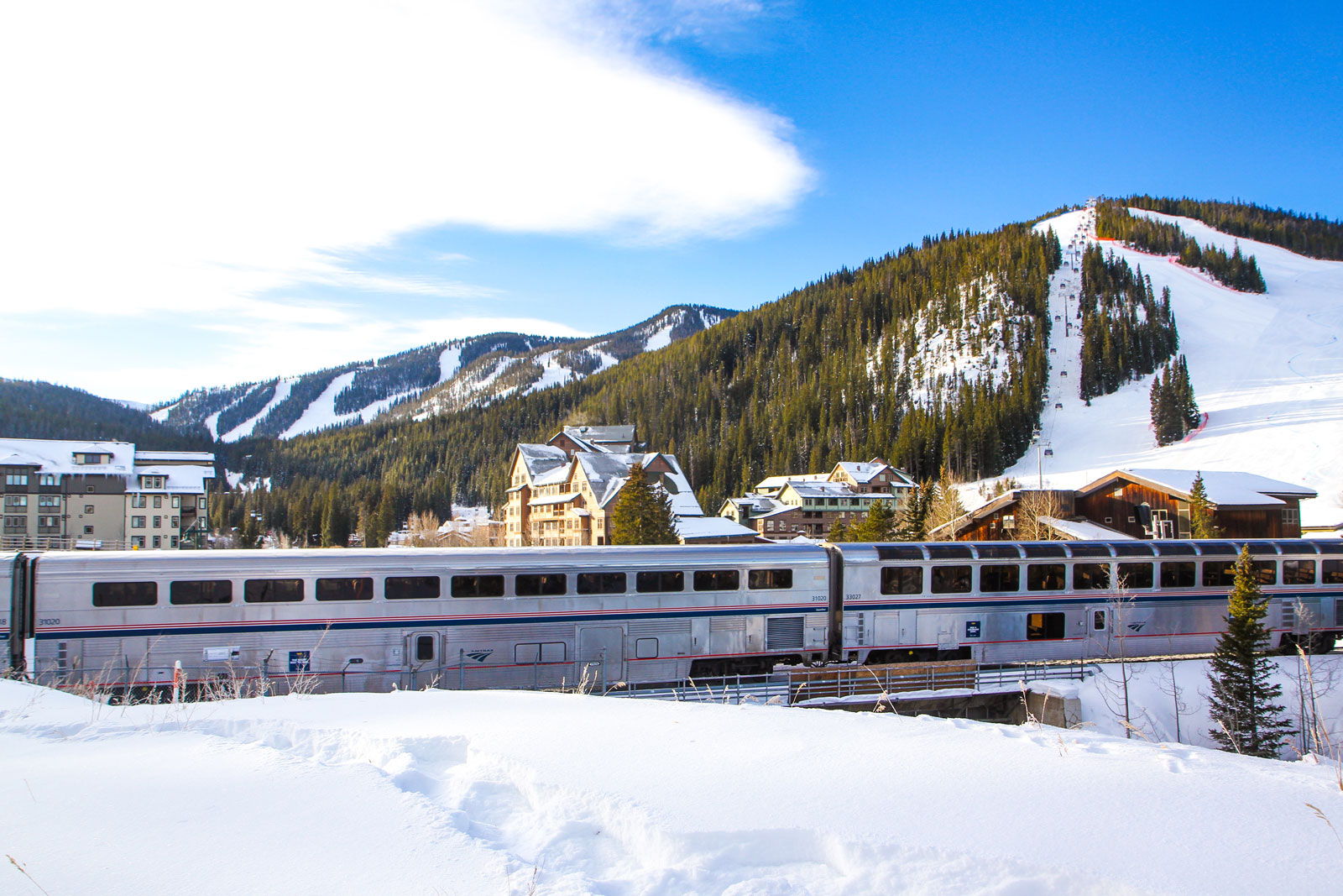 An Amtrak train chugs through the town of Winter Park on a snowy day
