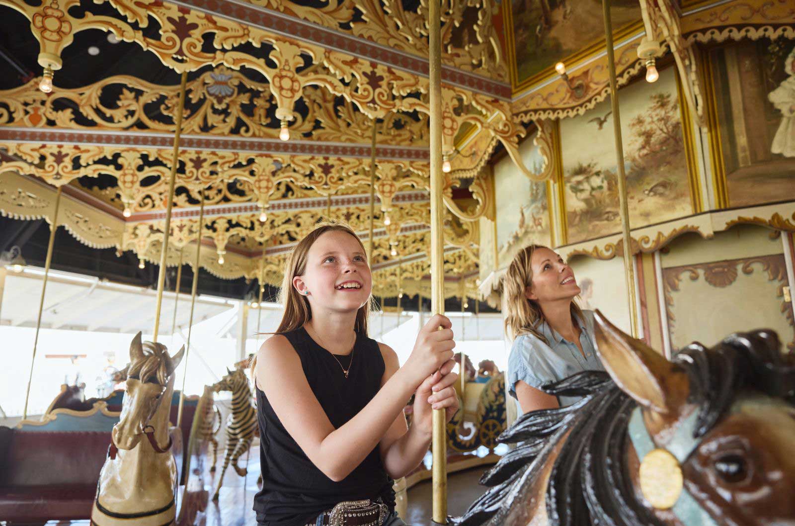 Two people ride horses on a carousel in Burlington, CO