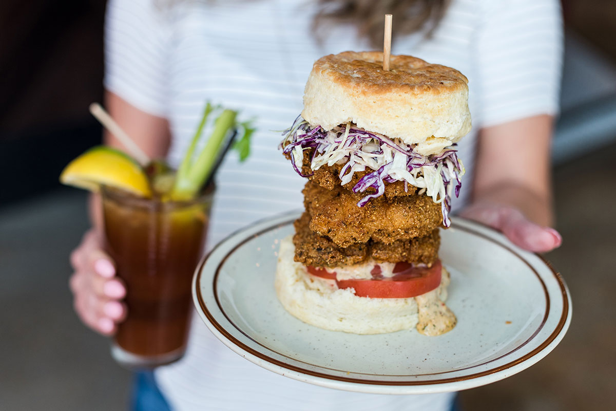 A large fried chicken sandwich with coleslaw is served at a restaurant in Aurora, Colorado.