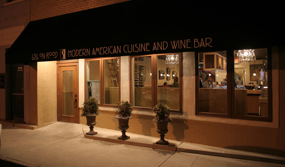 The front entrance of 626 on Rood at night. A black awning reads "626 on Rood - Modern American Cuisine and Wine Bar." The restaurant appears to be closed for the night.
