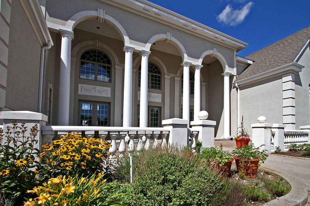 Tall, elegant columns with decorated arches and windows with matching silhouettes welcome guests to the Claremont Inn & Winery in Stratton, Colorado.