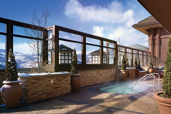 A steamy pool on a rooftop patio with mountain views
