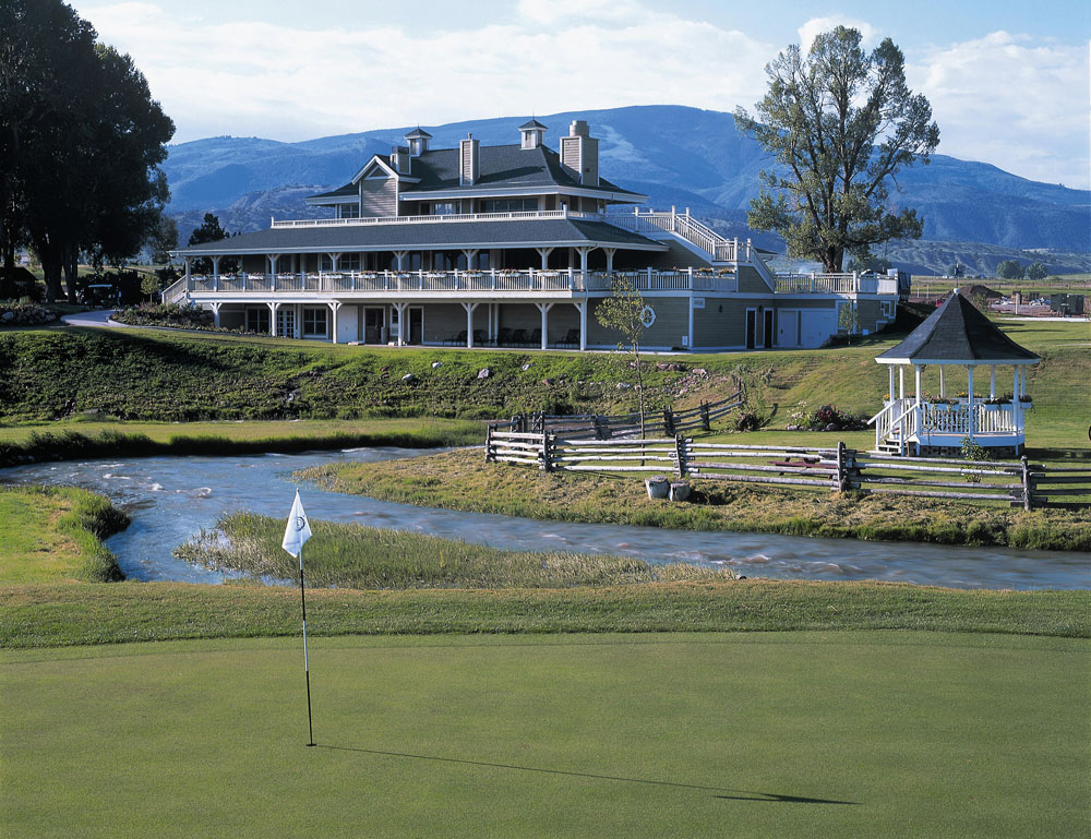 A small white flag marks the golf hole and a well-maintained, green golf course in Gypsum, Colorado.